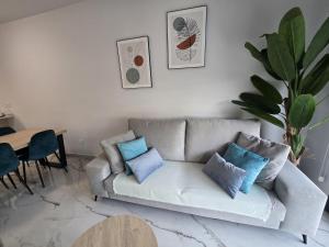 a living room with a couch with pillows on it at Playa Flamenca modern groundfloor apartment with pool access in Orihuela Costa