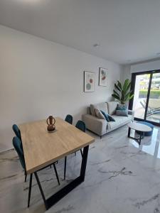 a living room with a table and a couch at Playa Flamenca modern groundfloor apartment with pool access in Orihuela Costa