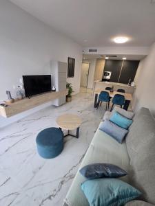 a living room with a couch and a table at Playa Flamenca modern groundfloor apartment with pool access in Orihuela Costa +39 photos