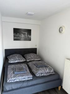 a bed in a room with two pillows and a clock at FeWo Hess in Rust