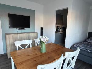 a living room with a table with a vase of flowers on it at FeWo Hess in Rust