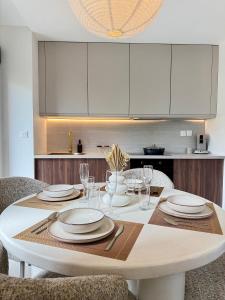 a white table with plates and glasses on it in a kitchen at Ambre du lagon in Saint-Pierre +18 photos