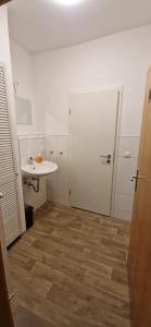 a bathroom with a sink and a white door at Privatpension Dreger in Alzey