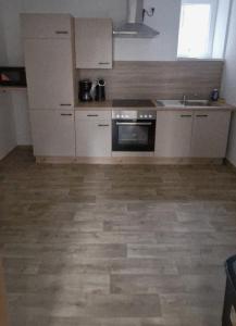 a kitchen with white appliances and a wooden floor at Privatpension Dreger in Alzey
