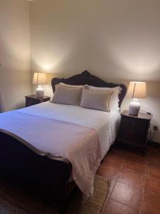 a bedroom with a large bed with two lamps at Quinta do Pomarinho - Arouca in Arouca