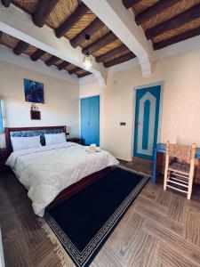 a bedroom with a large bed and a chair at Riad lina in Tafraout +20 photos