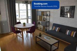 a living room with a table and a couch at Pour une agréable pause au Parc ! in Alençon