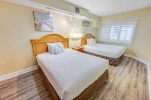 a hotel room with two beds and a window at New Beachfront, Condo Simply Amazing Pools & Views in Myrtle Beach