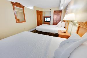 a hotel room with two beds and a mirror at New Beachfront, Condo Simply Amazing Pools & Views in Myrtle Beach