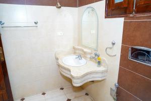 a bathroom with a sink and a mirror at Aisha Guest House And Restaurant in Al Aqālitah