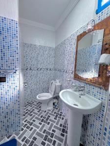 a bathroom with a sink and a toilet and a mirror at Riad lina in Tafraout