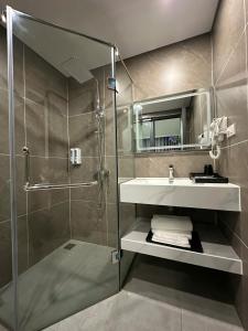 a bathroom with a shower and a sink and a mirror at Nhật Tân Hotel Vĩnh Ngọc II- Đông Anh in Dong Anh