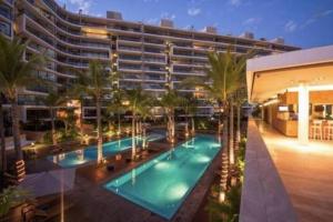 a large building with a swimming pool and palm trees at Nima bay in Puerto Vallarta