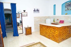 a kitchen with a counter in the middle of a room at Aisha Guest House And Restaurant in Al Aqālitah +39 photos
