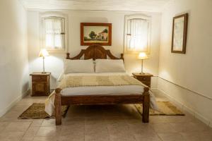 a bedroom with a bed with two lamps on two tables at La estancia Yapeyú in Yapeyú