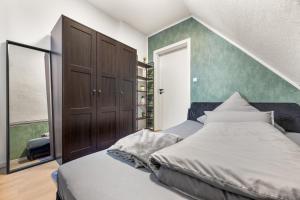 a bedroom with a large bed and a green wall at Heide Ferienwohnung West Nr-4 in Schneverdingen