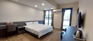 a bedroom with a bed and a desk and a television at Shin Mei B&B in Puli