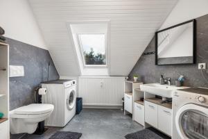 a bathroom with a washing machine and a sink at Heide Ferienwohnung West Nr-4 in Schneverdingen +23 photos