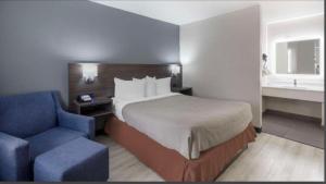 a hotel room with a bed and a blue chair at Downtown Inn & Studio Suites in Memphis
