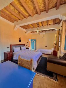 a bedroom with two beds and a couch at Riad lina in Tafraout