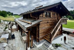 a log cabin with a wooden roof and stairs at Chalet Flond in Obersaxen