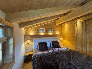 a bedroom with a bed in a room with wooden walls at Chalet Flond in Obersaxen