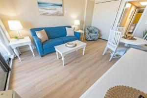 a living room with a blue couch and a table at Direct Ocean Front, The Pavilion, Pools, Boardwalk in Myrtle Beach
