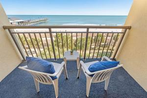 a balcony with chairs and a view of the beach at Direct Ocean Front, The Pavilion, Pools, Boardwalk in Myrtle Beach