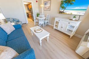 a living room with a blue couch and a table at Direct Ocean Front, The Pavilion, Pools, Boardwalk in Myrtle Beach