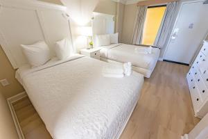 a large hotel room with two beds and a window at Direct Ocean Front, The Pavilion, Pools, Boardwalk in Myrtle Beach +44 photos