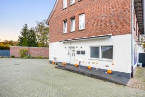 a white house with pumpkins in front of it at Heide Ferienwohnung West Nr-4 in Schneverdingen