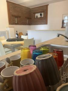 a kitchen counter with colorful cups and a sink at La Gisina B&B in Gaglianico