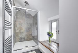 a bathroom with a shower with a vase of flowers at 5 Bed in Machynlleth oc-bow30 in Darowen +37 photos
