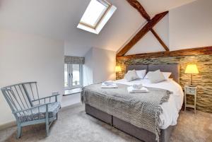 a bedroom with a large bed and a chair at 5 Bed in Machynlleth oc-bow30 in Darowen