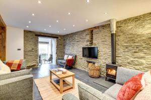 a living room with a stone wall and a fireplace at 5 Bed in Machynlleth oc-bow30 in Darowen