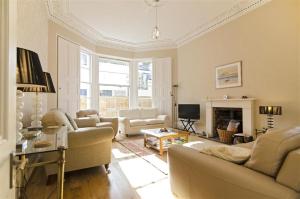 a living room with white furniture and a fireplace at 5 Bed in Torquay oc-rutlod in Torquay