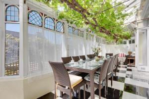 a dining room with a table and chairs and windows at 5 Bed in Torquay oc-rutlod in Torquay