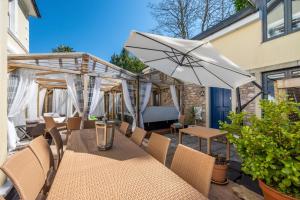 a patio with a table with an umbrella and chairs at 5 Bed in Torquay oc-rutlod in Torquay