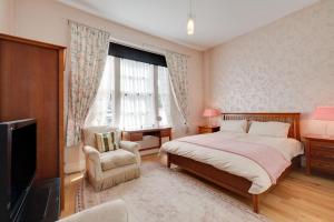 a bedroom with a bed and a tv and a chair at 5 Bed in Torquay oc-rutlod in Torquay