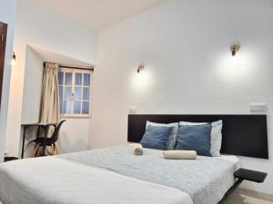 a bedroom with a large bed with blue pillows at The Central Guesthouse in Faro