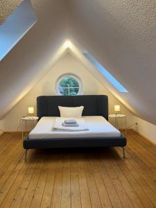 a bedroom with a bed in a attic with a window at Cliner Blick in Wittmund