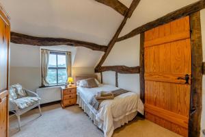 a bedroom with a bed and a wooden door at 3 Bed in Denbigh oc-waf147 in Gwaynynog