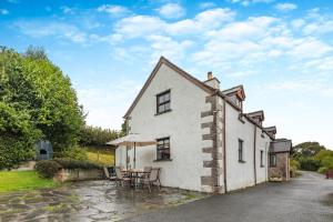 a white cottage with a table and chairs at 3 Bed in Denbigh oc-waf147 in Gwaynynog
