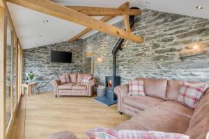 a living room with two couches and a stone wall at 4 Bed in Bala oc-bow66 in Bala