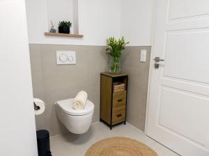 a bathroom with a toilet and a vase on a cabinet at Ferienwohnung Seeschlösschen am Dümmer See in Lembruch