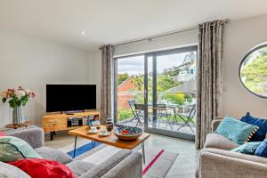 a living room with a tv and a large window at 2 Bed in Woolacombe oc-m29811 in Woolacombe