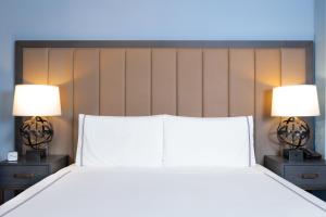 a bedroom with a bed with two lamps on both sides at Kixby in New York