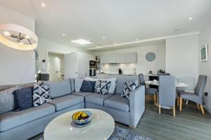 a living room with a blue couch and a kitchen at 3 Bed in Woolacombe oc-s29615 in Woolacombe