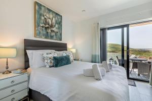 a bedroom with a large white bed with a balcony at 3 Bed in Woolacombe oc-s29615 in Woolacombe +14 photos