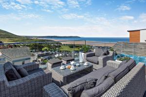 a patio with wicker furniture and a view of the ocean at 3 Bed in Woolacombe oc-s29615 in Woolacombe